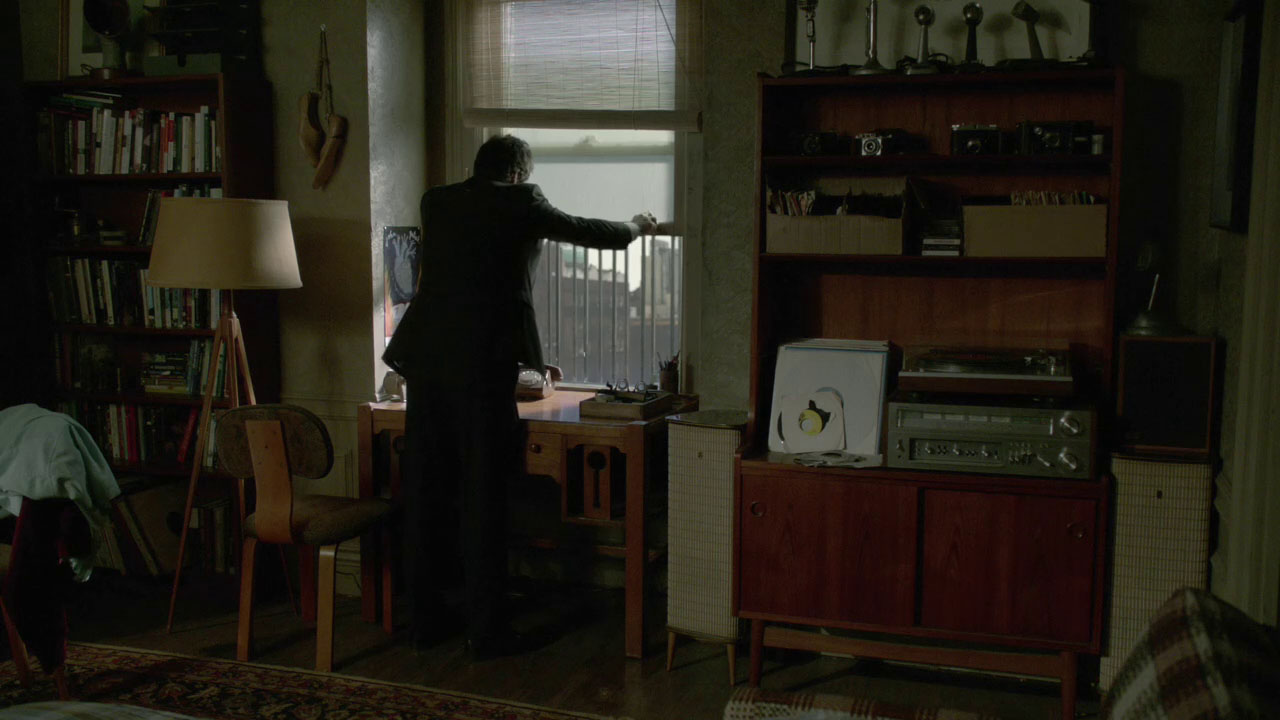 Neal's apartment in NYC with a Dreamcatch left of the window (Broken-2x01)